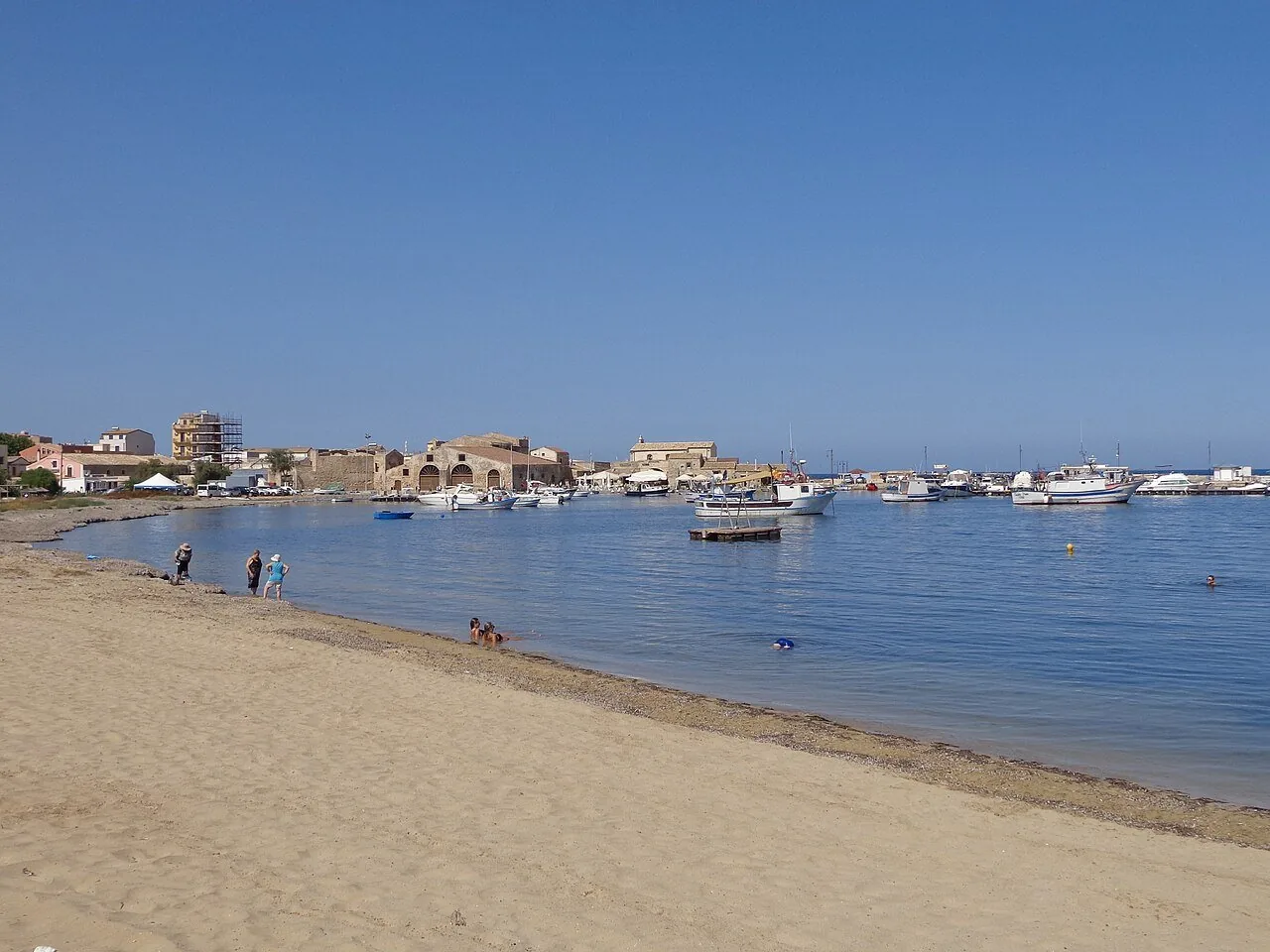 La spiaggia di Marzamemi con le barche ormeggiate e il borgo sullo sfondo